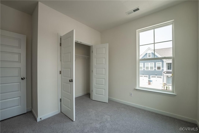 unfurnished bedroom with light carpet and a closet