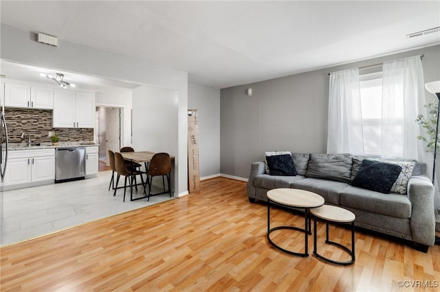 living room with sink and light wood-type flooring