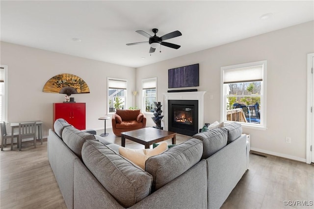 living room featuring ceiling fan, a healthy amount of sunlight, and light hardwood / wood-style floors