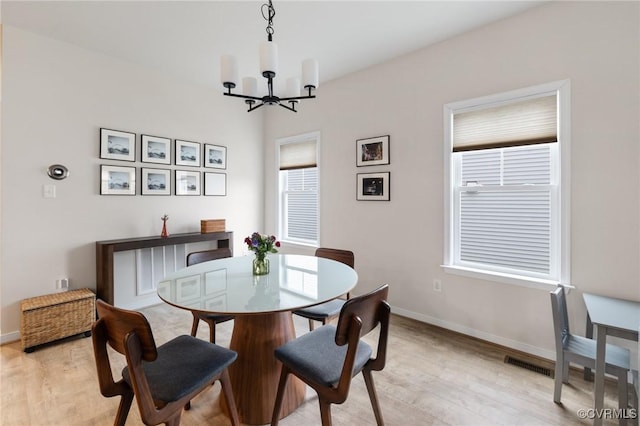 dining area with a chandelier and light hardwood / wood-style floors