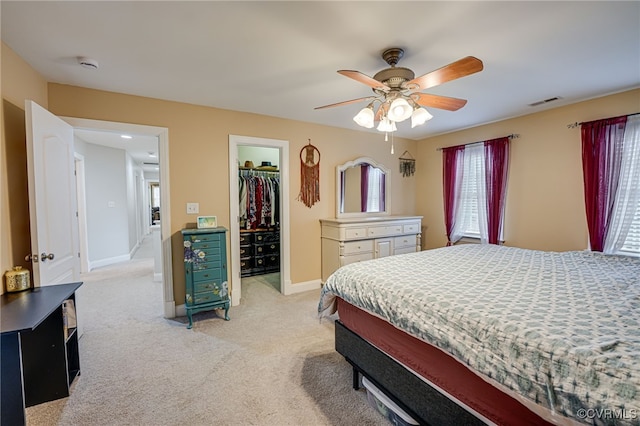 carpeted bedroom featuring ceiling fan, a spacious closet, and a closet