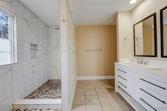 bathroom featuring plenty of natural light, vanity, and a tile shower