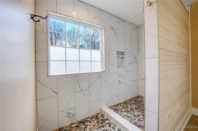 bathroom featuring a wealth of natural light and tiled shower