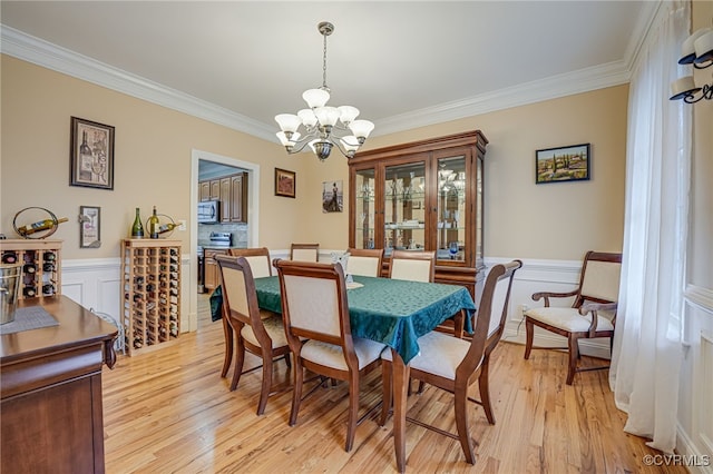 dining room featuring ornamental molding, a notable chandelier, and light wood-type flooring