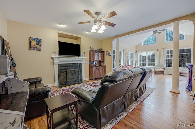 living room featuring vaulted ceiling, ceiling fan, decorative columns, and light wood-type flooring