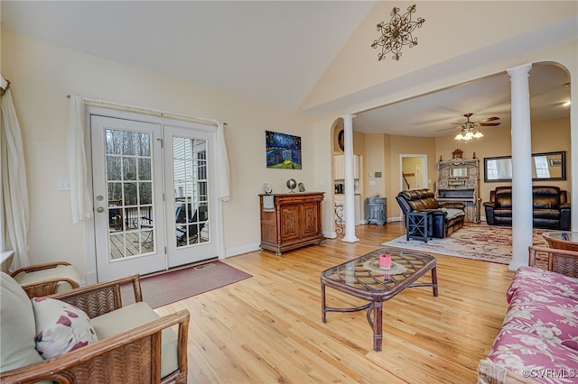 living room with decorative columns, high vaulted ceiling, hardwood / wood-style floors, and ceiling fan