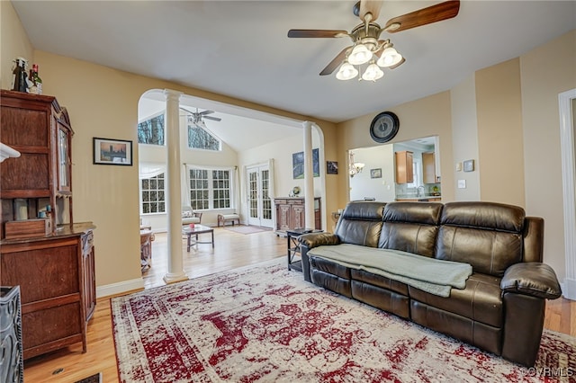 living room with vaulted ceiling, ceiling fan, decorative columns, and light wood-type flooring