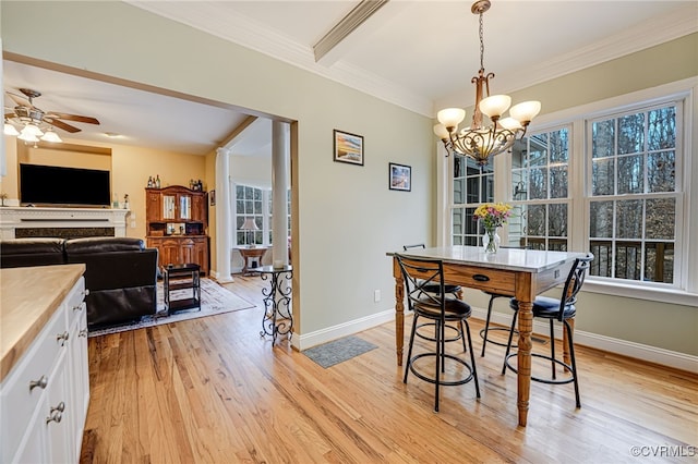 dining area with crown molding, plenty of natural light, ceiling fan with notable chandelier, and light wood-type flooring