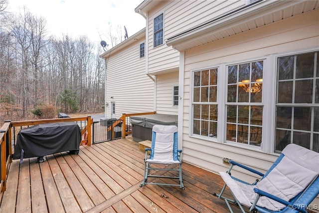 wooden terrace with area for grilling and a hot tub