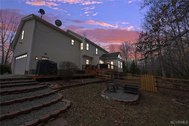 back house at dusk featuring a deck