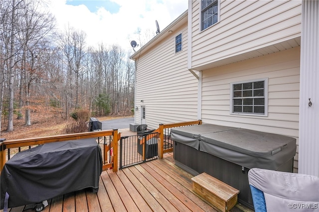 wooden terrace with area for grilling and a hot tub