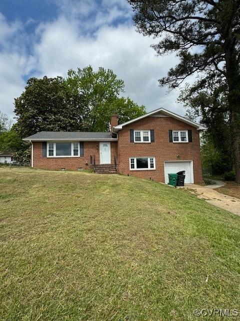 tri-level home featuring a garage and a front yard