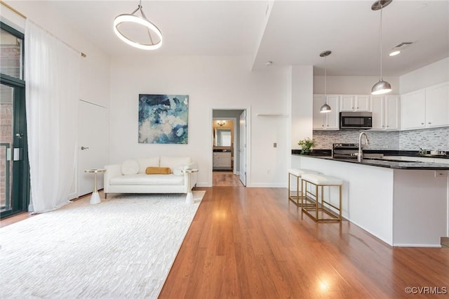 unfurnished living room with sink and light hardwood / wood-style flooring