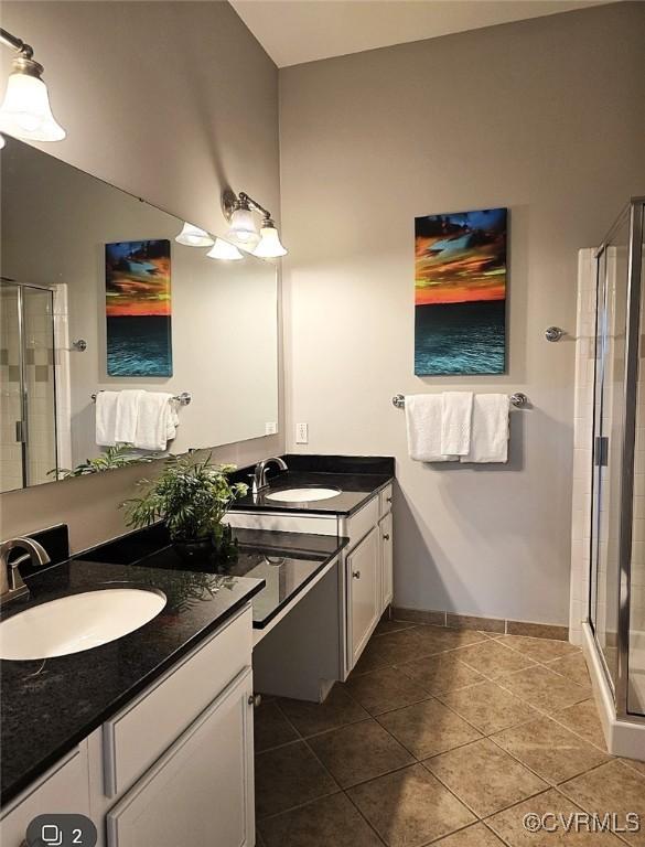 bathroom featuring vanity, a shower with shower door, and tile patterned floors