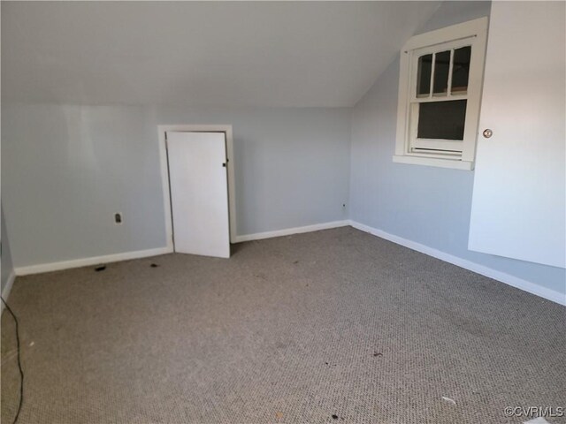 additional living space featuring lofted ceiling and carpet floors