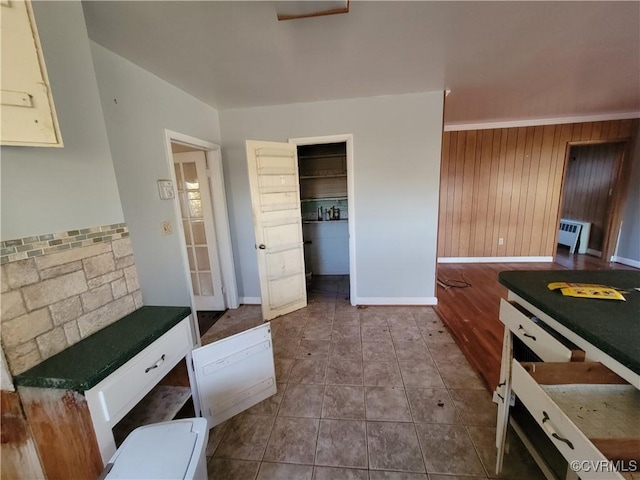 kitchen with tile patterned flooring and wooden walls