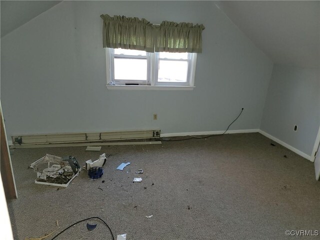 additional living space with a baseboard radiator and lofted ceiling