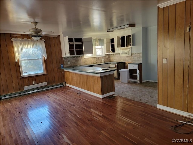 kitchen featuring kitchen peninsula, backsplash, dark hardwood / wood-style floors, and baseboard heating