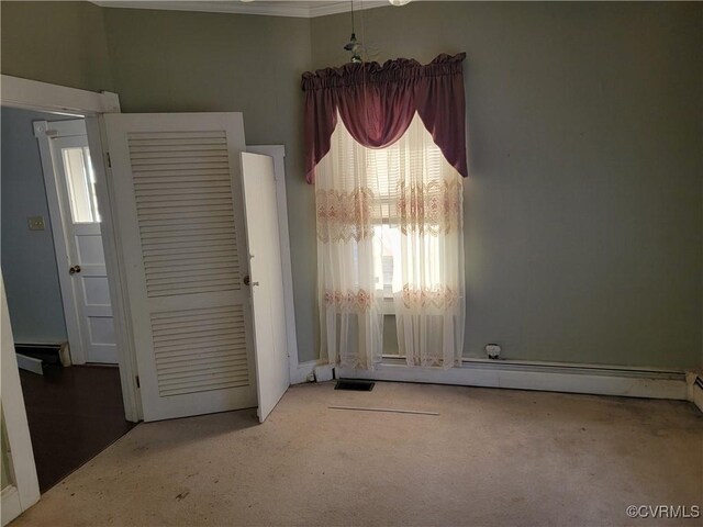 carpeted spare room featuring a baseboard heating unit