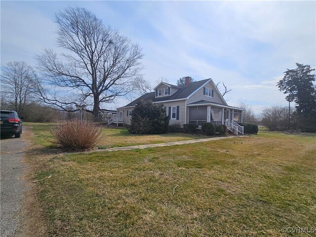 view of property exterior featuring aphalt driveway, a chimney, and a yard