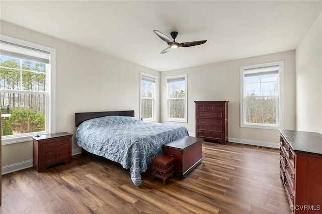 bedroom featuring multiple windows, ceiling fan, and dark hardwood / wood-style flooring