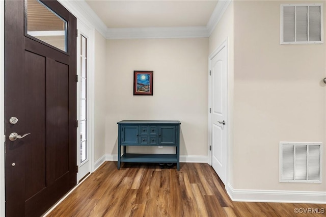 foyer entrance featuring crown molding and dark hardwood / wood-style floors