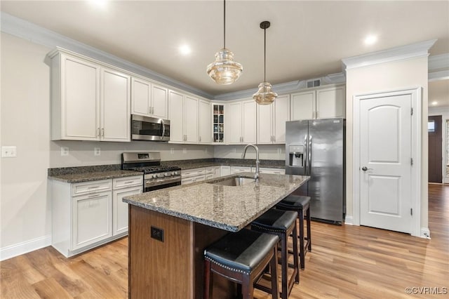 kitchen featuring white cabinetry, appliances with stainless steel finishes, sink, and a kitchen island with sink