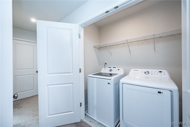 clothes washing area with independent washer and dryer and light carpet