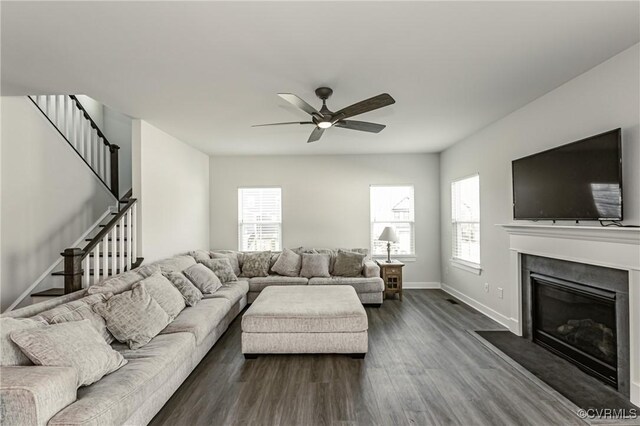 living room featuring dark wood-type flooring, a wealth of natural light, and ceiling fan