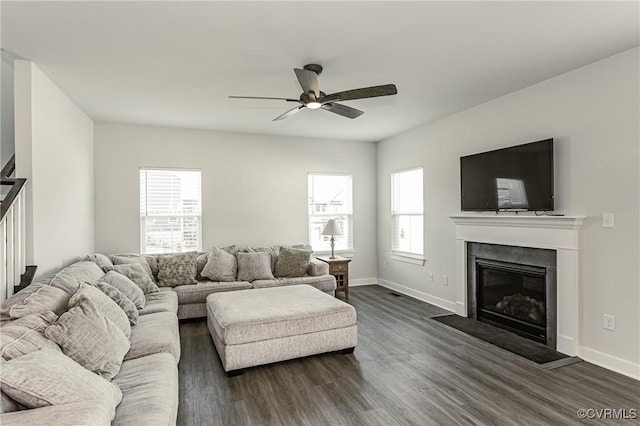 living room featuring a healthy amount of sunlight, dark wood-type flooring, and ceiling fan