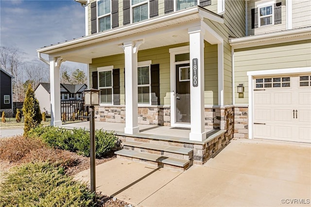 doorway to property with a garage and covered porch