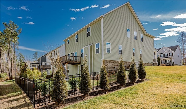 back of house with a balcony and a yard