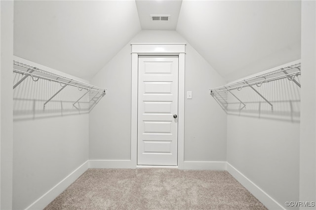 spacious closet with vaulted ceiling and carpet flooring