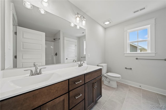 bathroom with vanity, tile patterned floors, toilet, and a shower