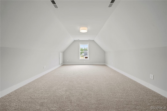 additional living space featuring carpet flooring and vaulted ceiling