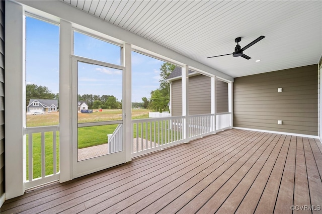 unfurnished sunroom featuring ceiling fan