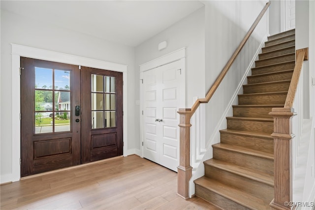 foyer with light wood-type flooring and french doors