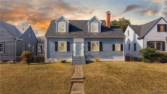 cape cod home with a lawn