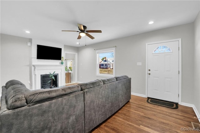 living room with wood-type flooring and ceiling fan