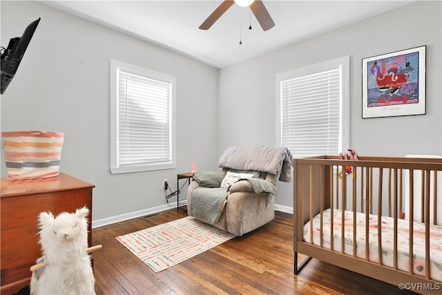 bedroom with dark hardwood / wood-style flooring and ceiling fan