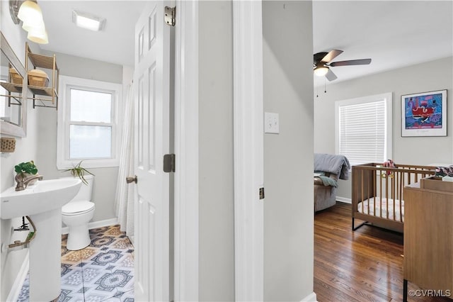 bathroom featuring hardwood / wood-style flooring, ceiling fan, and toilet