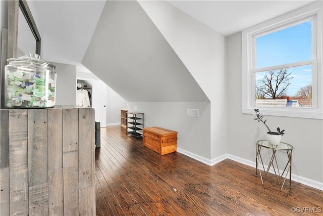 bonus room with dark wood-type flooring and vaulted ceiling