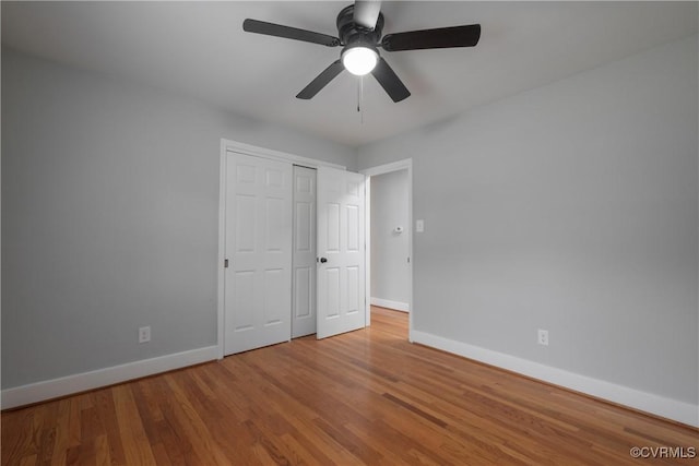 unfurnished bedroom featuring hardwood / wood-style floors, ceiling fan, and a closet