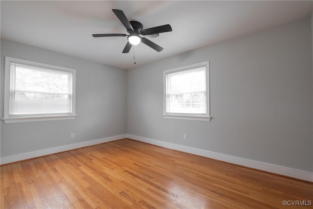 empty room with ceiling fan and light hardwood / wood-style flooring