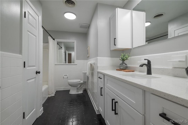 full bathroom featuring vanity, tile walls, shower / bath combination with curtain, and toilet