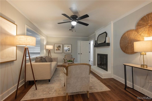 living room with a fireplace, dark wood-type flooring, ornamental molding, and ceiling fan