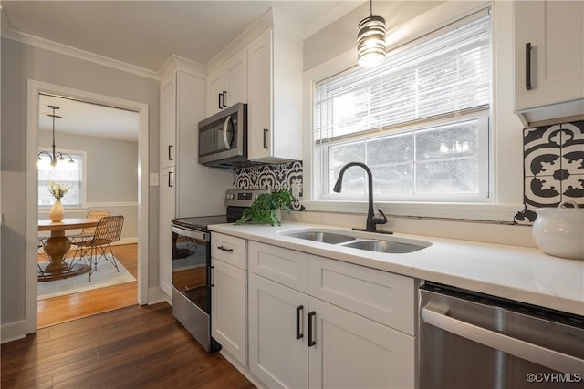 kitchen featuring sink, white cabinets, ornamental molding, stainless steel appliances, and dark wood-type flooring