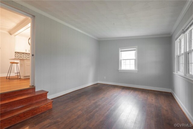 empty room featuring ornamental molding and dark hardwood / wood-style flooring