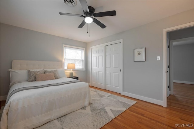 bedroom featuring ceiling fan, wood-type flooring, and a closet