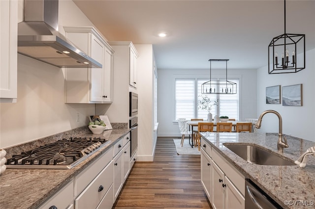 kitchen with wall chimney exhaust hood, stainless steel appliances, sink, and white cabinets